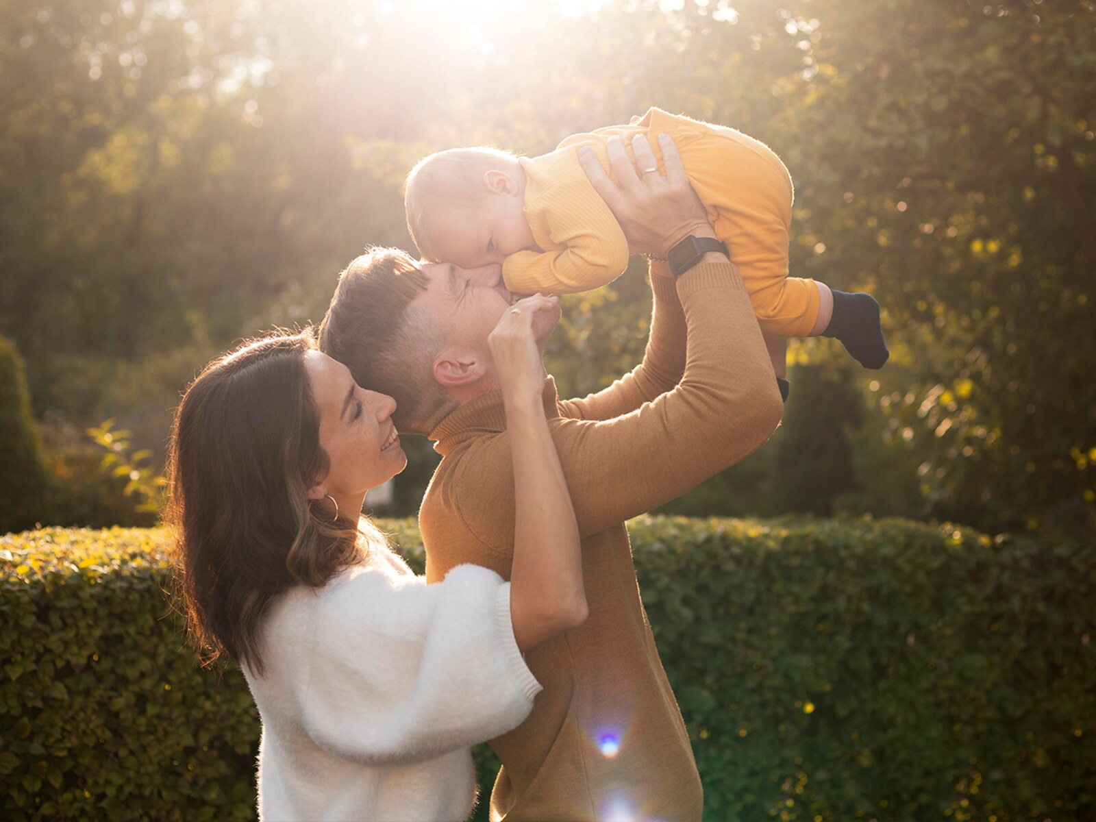Pai e mãe brincando com o bebê ao ar livre